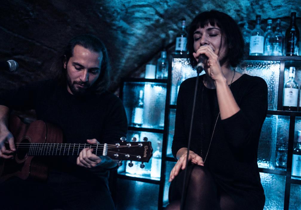 An acoustic duo performing in the corner of the cellar bar